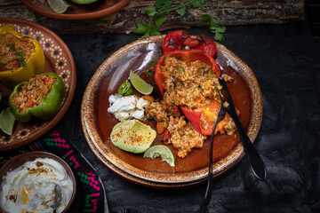Vegetarian rice stuffed peppers along with side dishes in a traditional Mexican setting