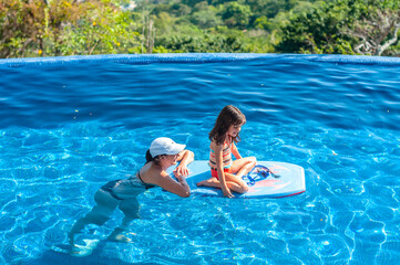 Madre y niña en alberca durante vacaciones de verano