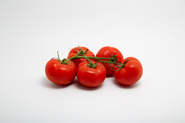 Close up shot of a bunch of fresh red organic tomatoes isolated on white background with copy space