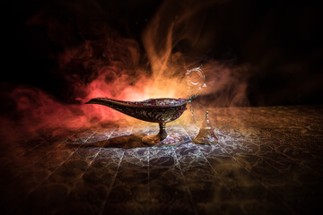 Lamp of wishes concept. Antique Aladdin arabian nights genie style oil lamp with soft light white...