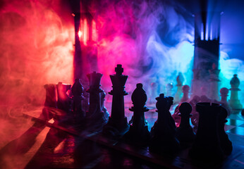 Chess figures on a dark background with smoke and fog. Selective focus