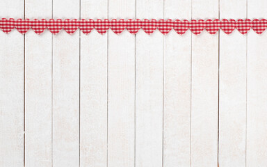 Red and White Valentines Day Hearts in a Row at the top of White Boards Background with copy space below.  It's a wide horizontal photo with vertical wood planks.