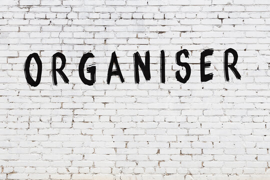 White wall with black paint inscription organiser on it