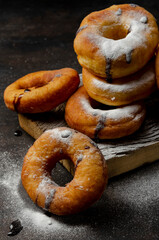 Donuts sprinkled with powdered sugar on dark