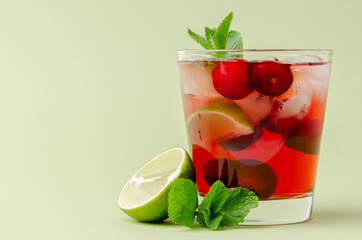 refreshing red cocktail with sparkling water and ice garnished with a lime