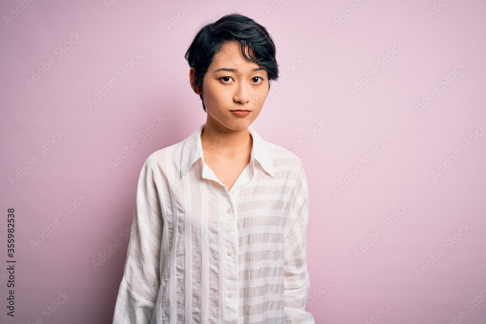 Poster Young beautiful asian girl wearing casual shirt standing over isolated pink background looking sleepy and tired, exhausted for fatigue and hangover, lazy eyes in the morning.