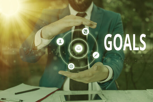 Writing note showing Goals. Business concept for desired result that an individual envision plan and commit to achieve