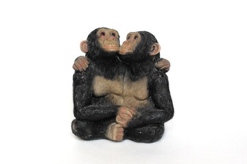 antique statuette of two cuddling monkeys on a white background