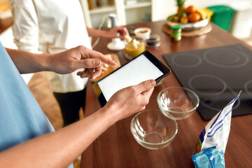 Best recipes. Man checking recipe using tablet pc while woman making smoothie. Vegetarians cooking in the kitchen together. Vegetarianism, healthy food, diet, stay home concept