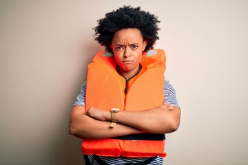 Young African American afro woman with curly hair wearing orange protection lifejacket skeptic and nervous, disapproving expression on face with crossed arms. Negative person.