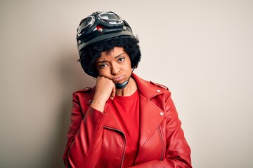 Young African American afro motorcyclist woman with curly hair wearing motorcycle helmet thinking looking tired and bored with depression problems with crossed arms.