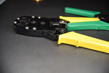 Yellow and green adjustable wire stripper isolated on a black background, Adjustable wire stripper isolated isolated a black background