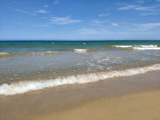 Fototapeta premium White waves runs on the yellow sand in sunny day