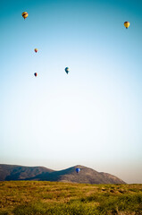 Balloon launch over field with mountains in background