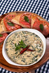 sopa de crema de champiñones con granos de elote, rajas poblanas, chile seco y trozos de pan con tomate rojo