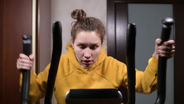 The girl trains, dries sweat with a towel and squeezes a wet towel through, then continues to workout