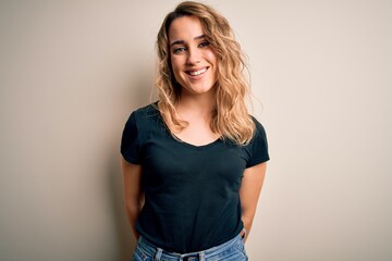 Young beautiful blonde woman wearing casual t-shirt standing over isolated white background with a happy and cool smile on face. Lucky person.