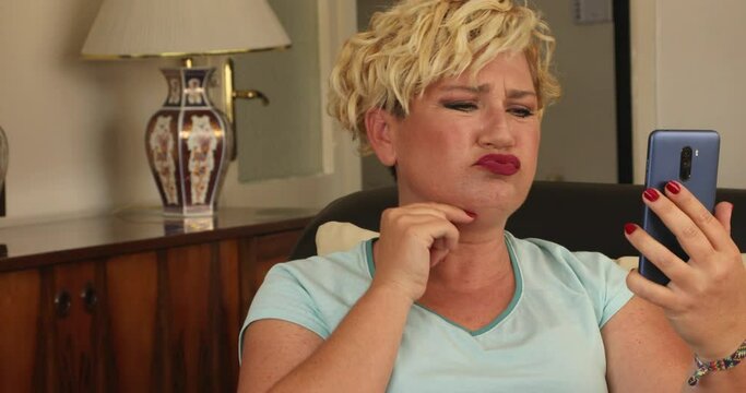 Portrait of a stressed middle aged woman looking into mirror feeling sad about fat neck