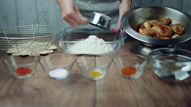 Adding flour into a glass bowl along with 1 TBSP of Salt, Soya sauce, Tomato Ketchup, Ginger paste, Garlic paste, Chilli paste, Black pepper powder. Concept of preparing the breading for juicy Chicken