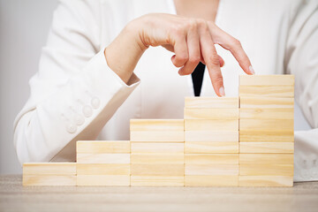 Business concept, woman's hands make up wooden cubes symbolizing the success of the company