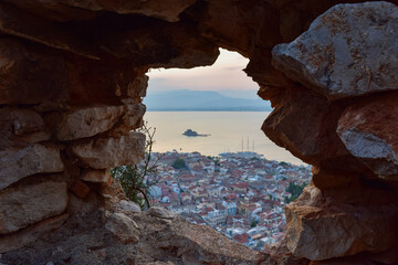 Biew of Nauplia from above at a summer evening sky through a wall