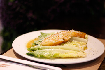Ensalada César de lechugas con pan y queso parmesano. 