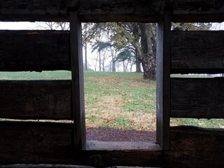 Fototapeta na wymiar window in log cabin looking outside to grass