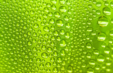 Close up water drops on light green tone background. Abstract sky light green wet texture with water drops on glass surface. 