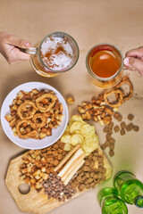 Drinking beer after work. Table full of beer snacks. Pouring bottle of cold beer into glass. Celebrating international beer day, Octoberfest, friends celebrate meeting