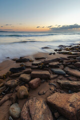 Wave water coming into the rocky coastline.