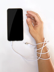 Man hands trapped and wrapped on wrists with mobile phone cable.