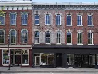 facade of old brick buildings with stores at street level and apartments above