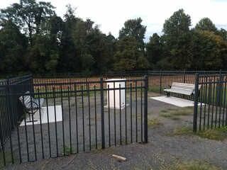 white box with benches and metal fence