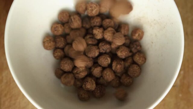 Chocolate Corn Balls Falling Into bowl. Slow Motion. chcolate ceral Breakfast.