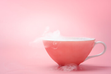 rose gold vintage tea cup with dry ice smoke on a dreamy pastel pink background