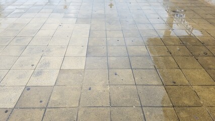 wet grey square floor tiles on ground