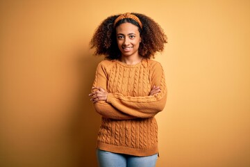 Young african american woman with afro hair wearing casual sweater over yellow background happy...