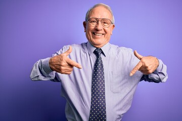 Grey haired senior business man wearing glasses standing over purple isolated background looking confident with smile on face, pointing oneself with fingers proud and happy.
