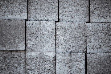 Background with grey construction bricks/blocks laying in a row on each other
