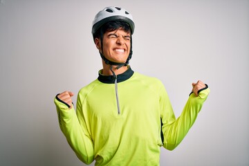 Young handsome cyclist man wearing security bike helmet over isolated white background very happy and excited doing winner gesture with arms raised, smiling and screaming for success. Celebration
