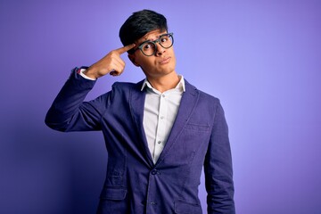 Young handsome business man wearing jacket and glasses over isolated purple background pointing...