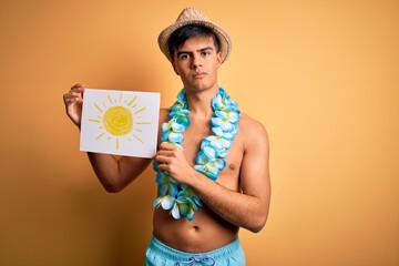 Tourist man on vacation wearing swimwear and hawaiian lei flowers holding banner with sun with a...