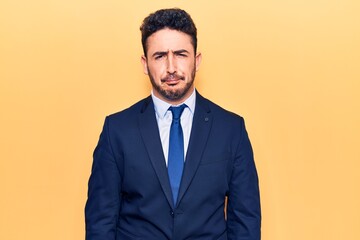 Young hispanic man wearing suit skeptic and nervous, frowning upset because of problem. negative person.