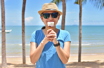 Smiling girl having fun eating icecream on a summer day outdoors.