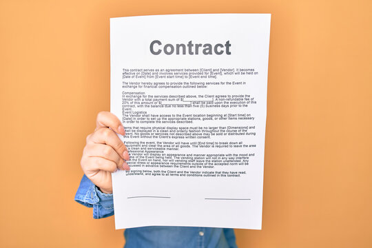 Woman holding contract document paper standing over isolated yellow background