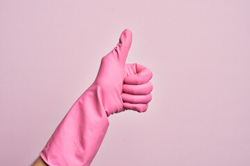 Hand of caucasian young man with cleaning glove over isolated pink background doing successful...