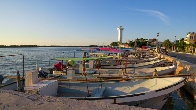 faro y lanchas de pescadores en el muelle por la tarde en rio lagartos mexico