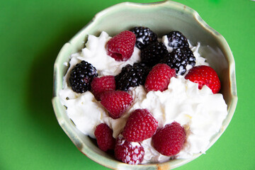 berries and whip cream in a bowl ready to eat