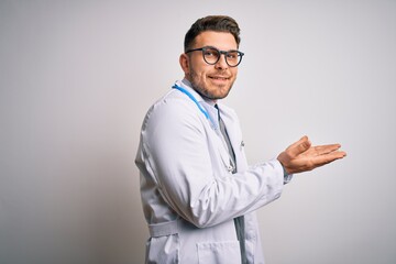 Young doctor man with blue eyes wearing medical coat and stethoscope over isolated background pointing aside with hands open palms showing copy space, presenting advertisement smiling excited happy