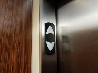 up and down arrows in elevator with metal door